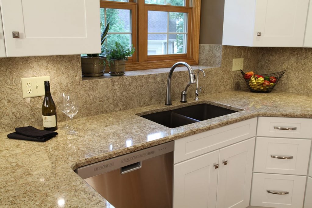 Kitchen cabinet refacing with new countertop and backsplash, featuring sink and faucet.