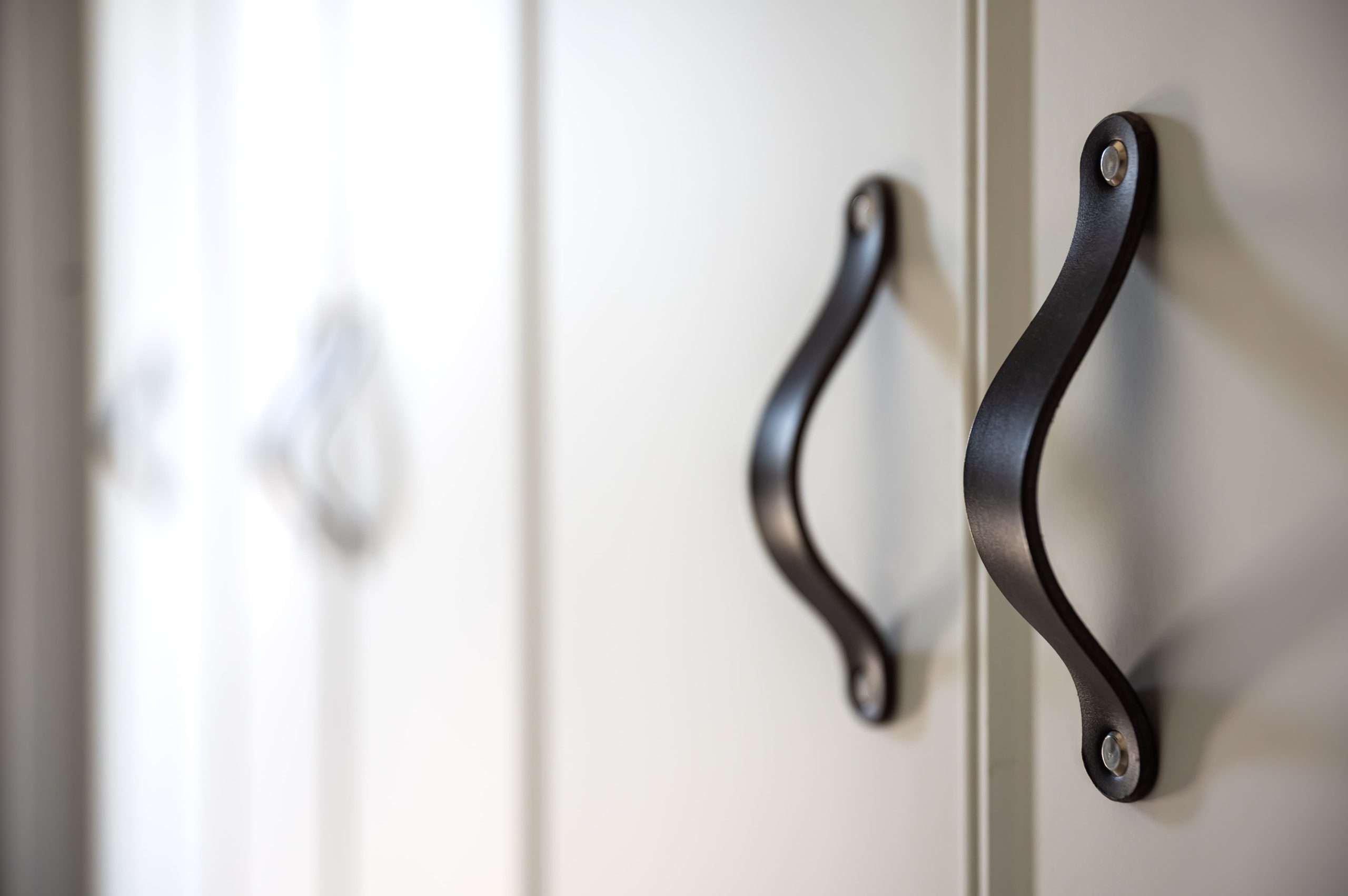 white kitchen cabinet with black handles