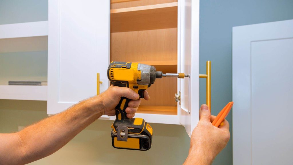 man installing new kitchen cabinet door