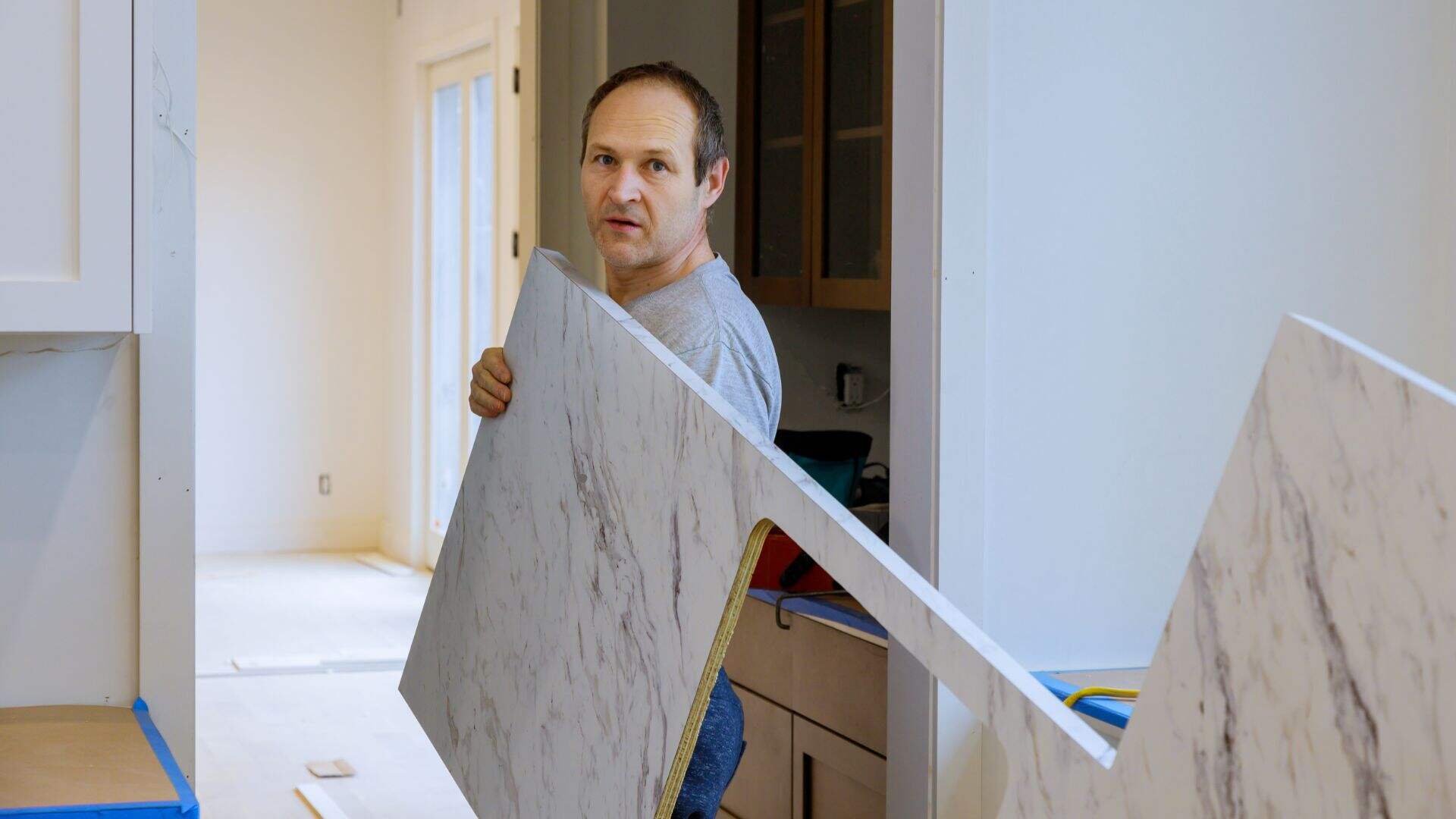 construction worker installing laminate kitchen counter top