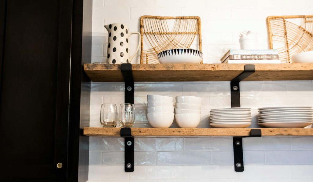 Dishware and glasses on shelves in cafe kitchen
